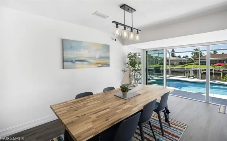 Dining room featuring visible vents, baseboards, and dark wood finished floors