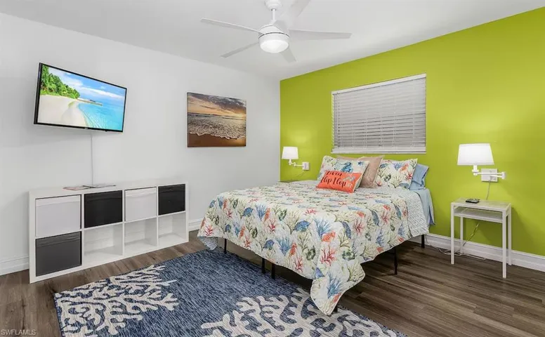 Bedroom with ceiling fan, baseboards, and wood finished floors