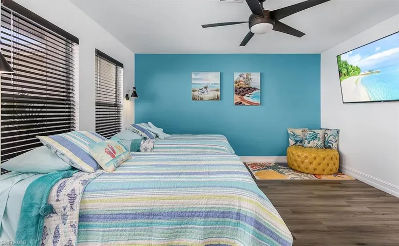 Bedroom featuring ceiling fan, baseboards, and wood finished floors