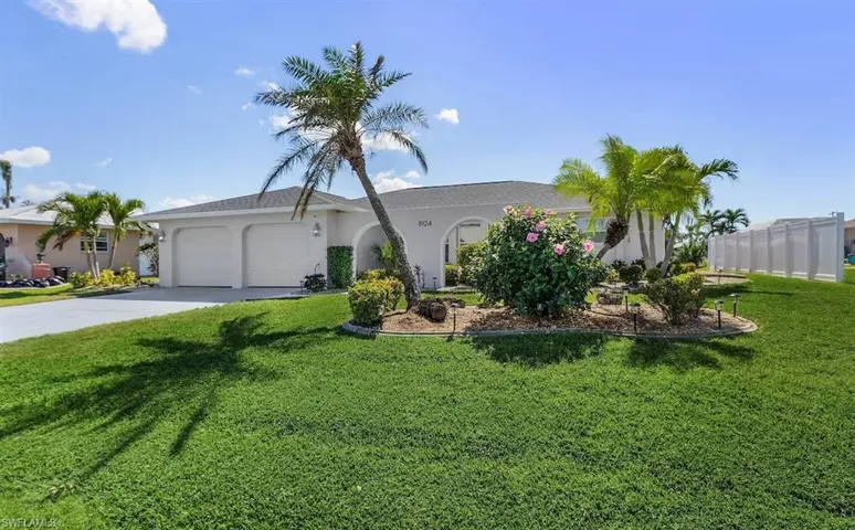 Ranch-style home featuring a garage, concrete driveway, a front yard, and stucco siding