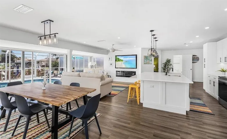 Dining room with dark wood-style floors, ceiling fan, visible vents, and recessed lighting