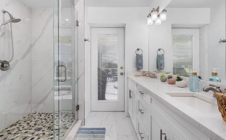 Bathroom featuring marble finish floor, a marble finish shower, and a sink