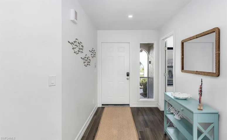 Entrance foyer with dark wood-style floors, recessed lighting, and baseboards