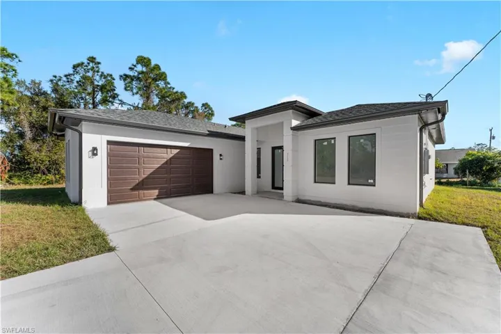 View of front facade featuring a garage and a front yard