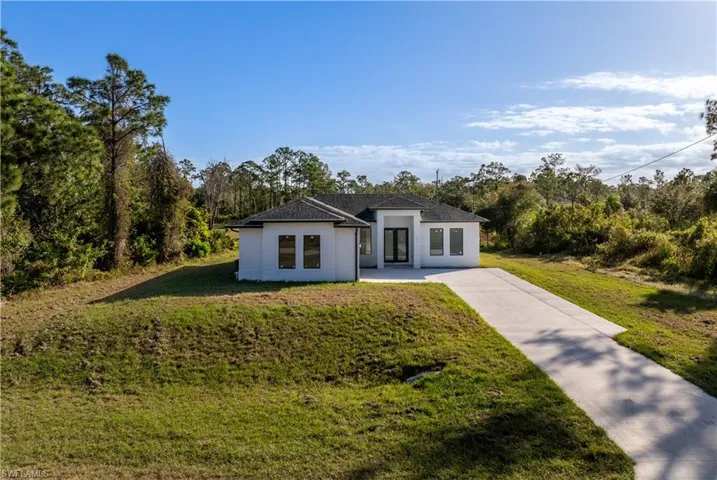 Ranch-style home featuring a front lawn