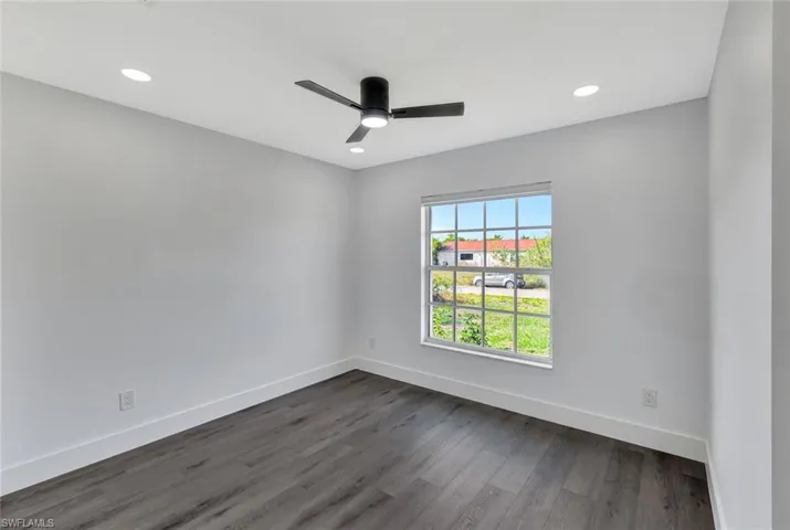 Spare room featuring dark wood-style flooring, recessed lighting, a ceiling fan, and baseboards