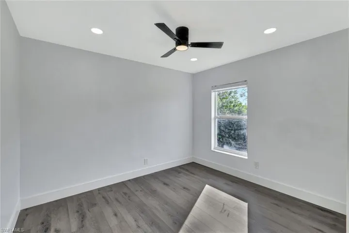 Spare room featuring recessed lighting, ceiling fan, baseboards, and wood finished floors