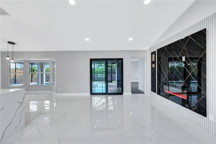 Unfurnished living room featuring a wealth of natural light, marble finish floor, and recessed lighting