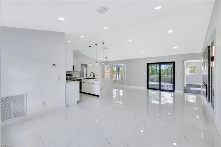Unfurnished living room with recessed lighting, marble finish floor, visible vents, and a sink