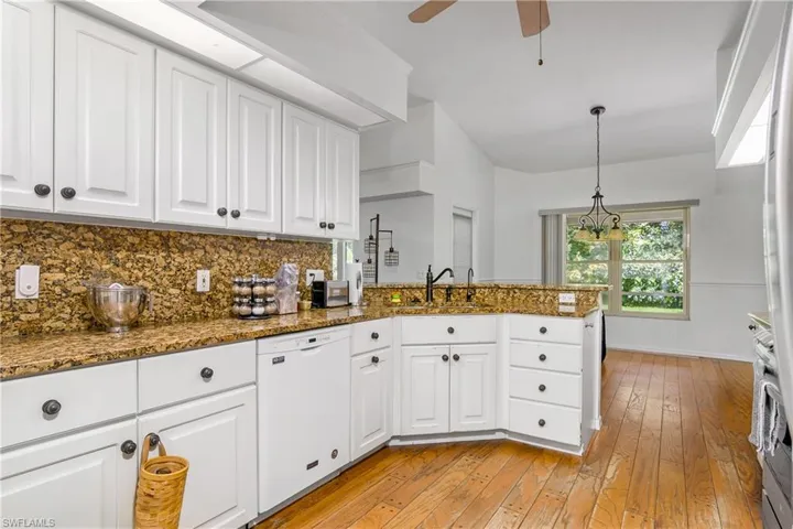 Kitchen with white cabinetry, ceiling fan, sink, dishwasher, and light hardwood / wood-style floors