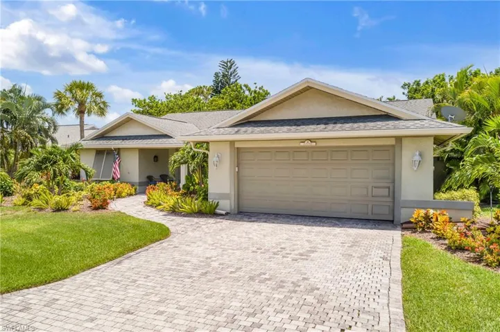 Single story home featuring a garage and a front yard