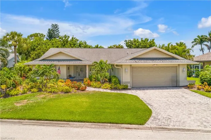 Single story home featuring a garage and a front yard