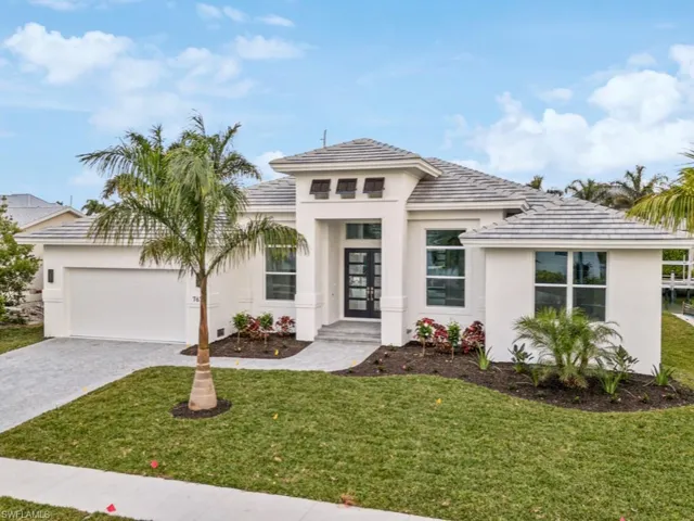 View of front facade featuring a front yard and a garage