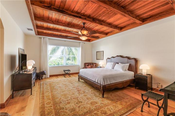 Custom pecky cypress slat and beam ceiling in primary bedroom