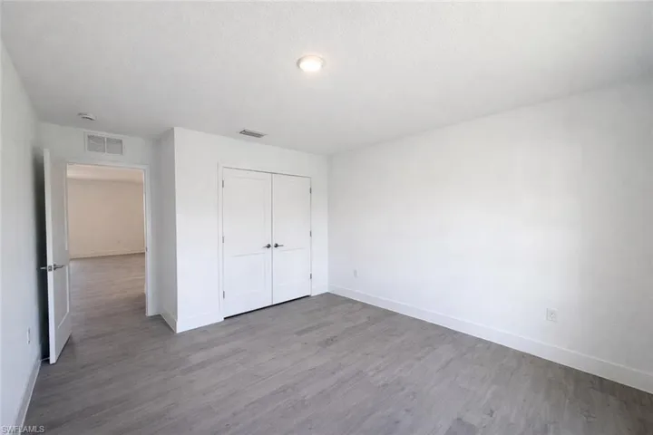 Unfurnished bedroom with wood finished floors, a closet, and a textured ceiling