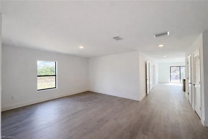 Spare room with light wood-type flooring, a textured ceiling, and recessed lighting