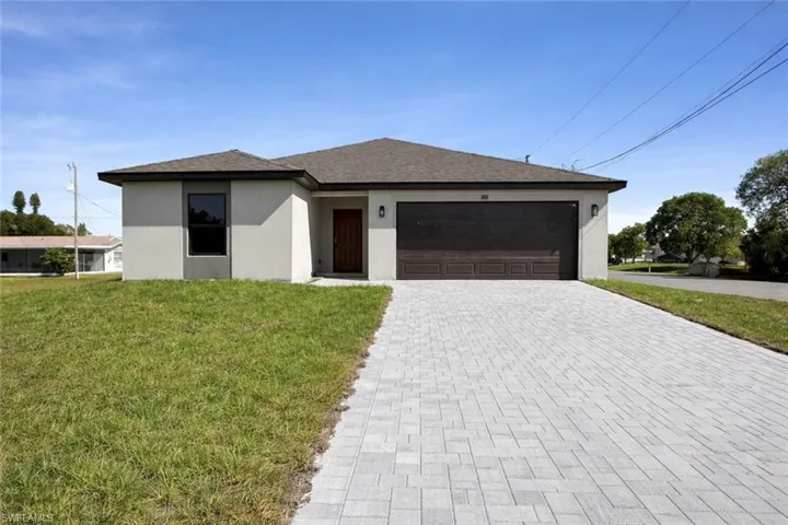 Single story home with stucco siding, a front yard, decorative driveway, a garage, and a shingled roof