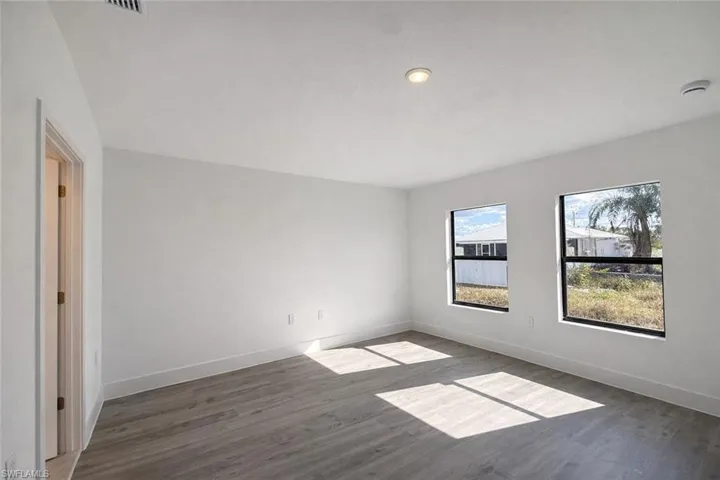 Empty room with dark wood-style floors and baseboards