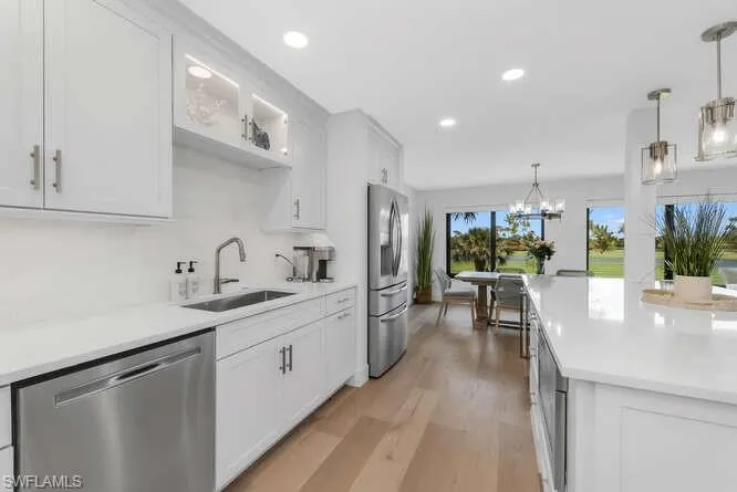 Kitchen featuring stainless steel appliances, a sink, light countertops, light wood finished floors, and recessed lighting