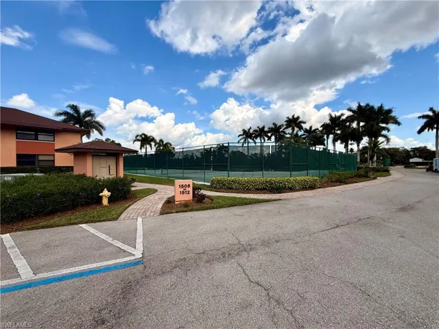 View of property's community featuring uncovered parking and a tennis court
