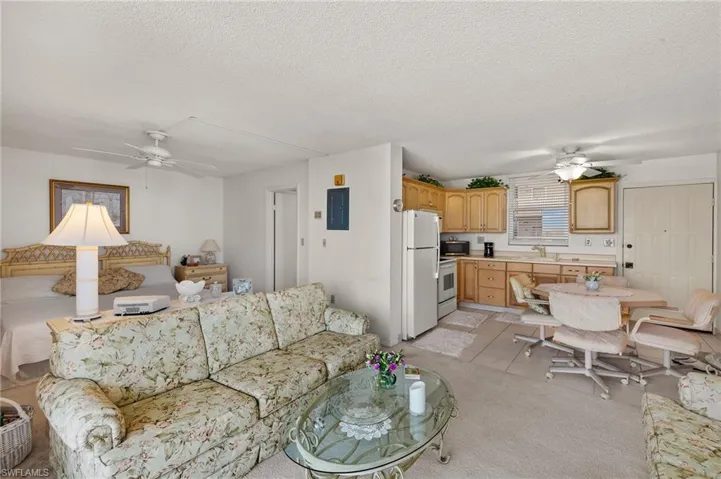 Living room featuring electric panel, a textured ceiling, and ceiling fan