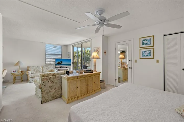 Bedroom featuring light carpet, a textured ceiling, and a ceiling fan