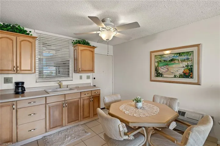 Kitchen featuring a textured ceiling, light countertops, light tile patterned flooring, and a sink
