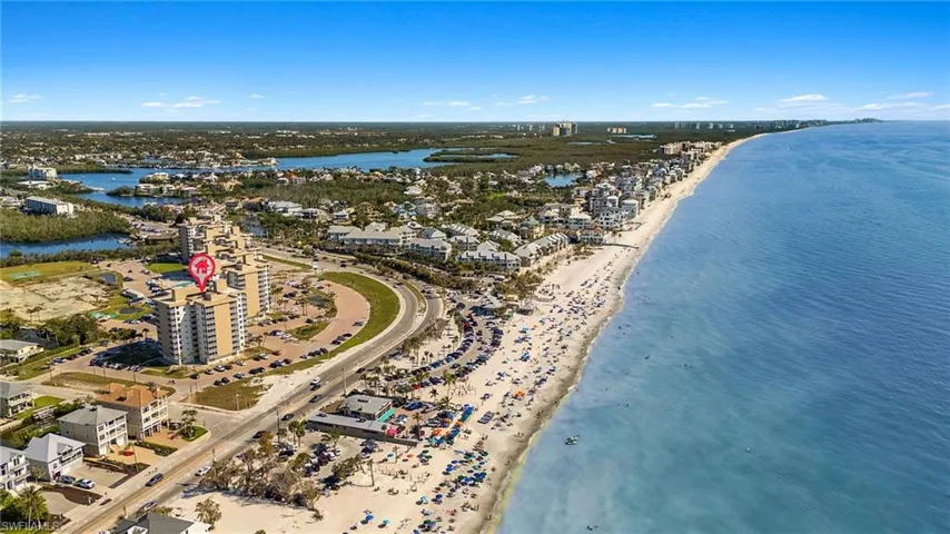 Birds eye view of property with a beach view and a water view
