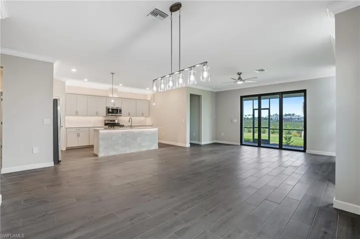 Unfurnished living room with ceiling fan, baseboards, a sink, dark wood-style flooring, and recessed lighting
