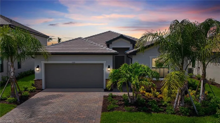 View of front of home featuring stucco siding, decorative driveway, an attached garage, and a tiled roof