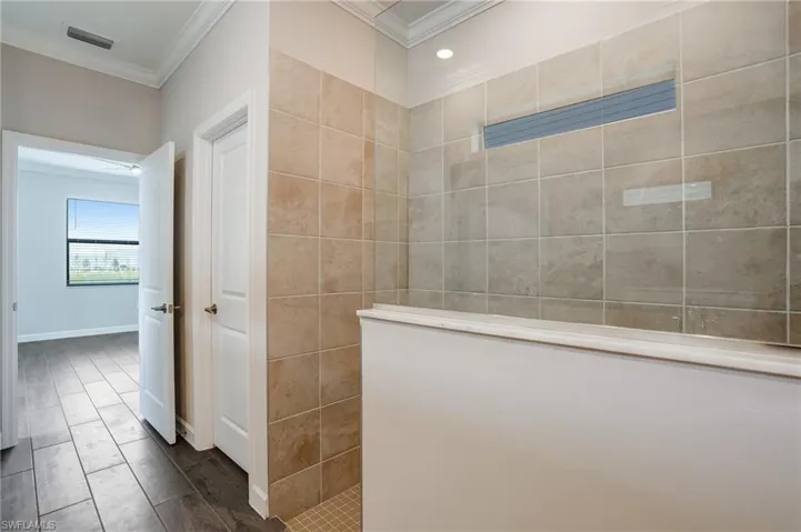 Full bathroom featuring crown molding and walk in shower