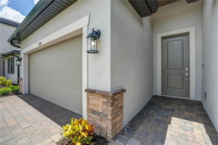 Doorway to property featuring stucco siding and driveway