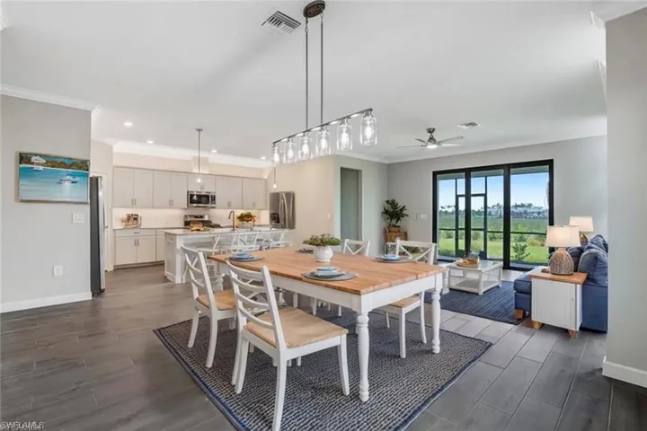 Dining space with dark wood-style floors, crown molding, a ceiling fan, baseboards, and recessed lighting