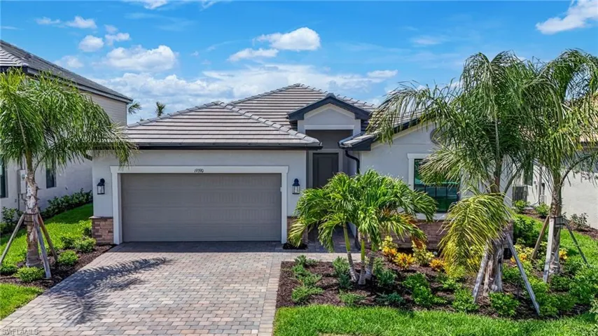 View of front of property featuring stucco siding, decorative driveway, an attached garage, and a tiled roof