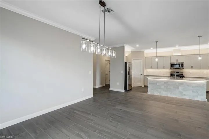 Kitchen with appliances with stainless steel finishes, crown molding, tasteful backsplash, baseboards, and recessed lighting