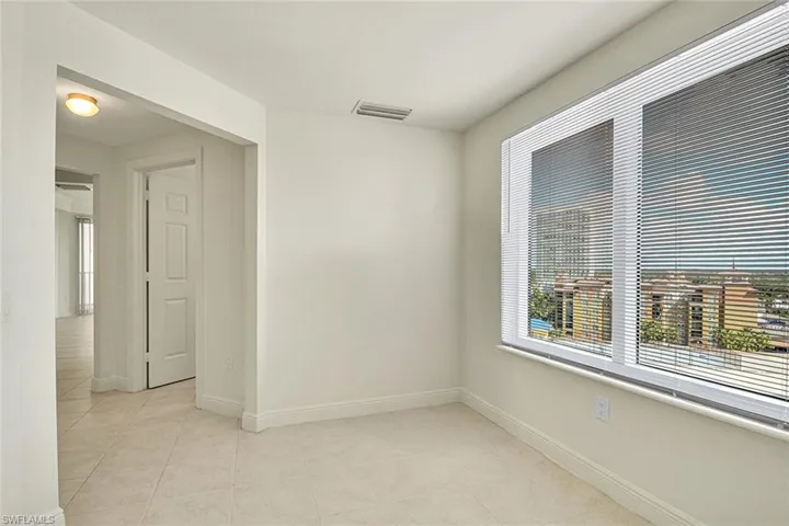 Empty room with baseboards and light tile patterned floors