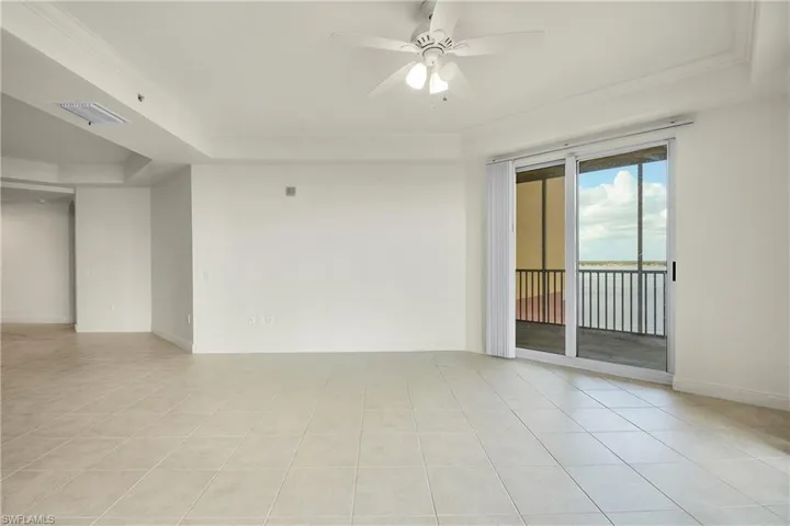Unfurnished room featuring light tile patterned floors, ceiling fan, and ornamental molding