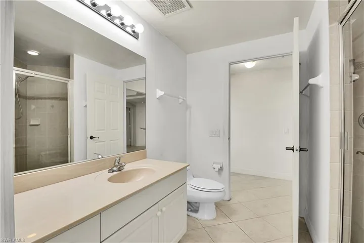 Full bathroom with a stall shower, light tile patterned floors, and vanity