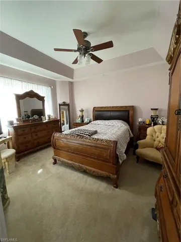 Master Bedroom featuring ceiling fan, light carpet, and lofted ceiling
