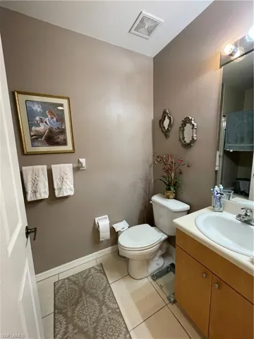 Bathroom featuring vanity, toilet, and tile patterned flooring