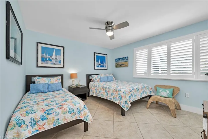 Tiled bedroom featuring ceiling fan