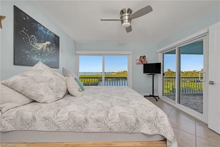 Bedroom featuring tile patterned flooring, ceiling fan, access to exterior, and multiple windows
