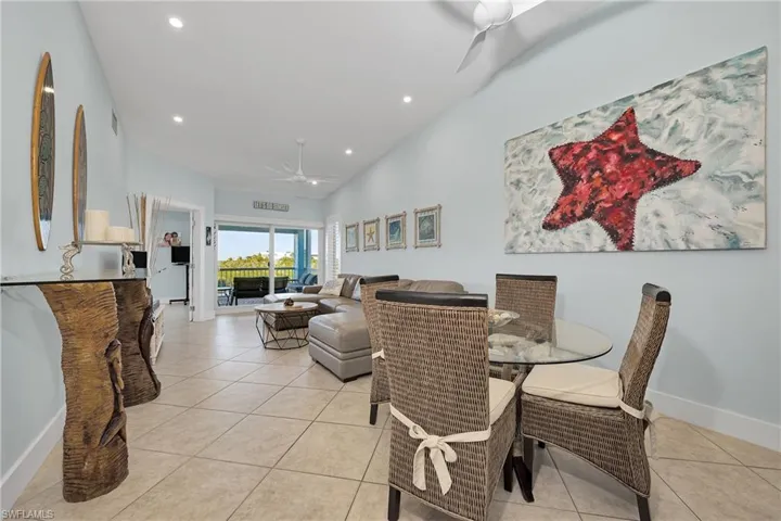 Tiled dining room with ceiling fan and lofted ceiling