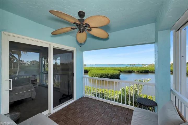 Unfurnished sunroom featuring ceiling fan and a water view