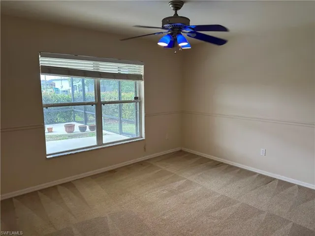 Unfurnished room featuring a ceiling fan, baseboards, and light colored carpet