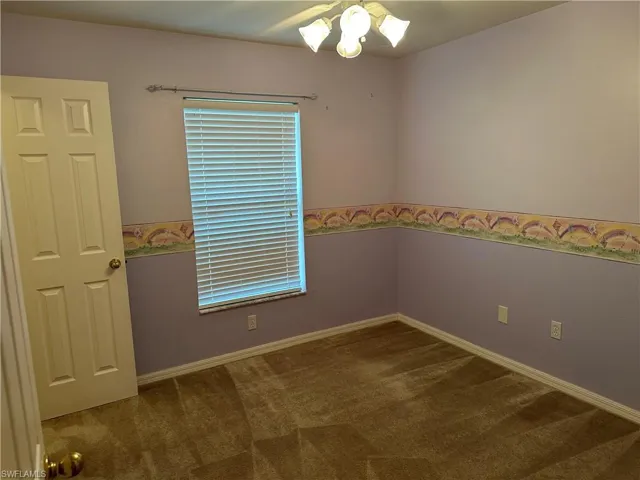 Carpeted empty room with baseboards and ceiling fan