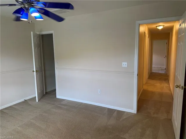Unfurnished bedroom featuring baseboards, visible vents, carpet floors, and a ceiling fan
