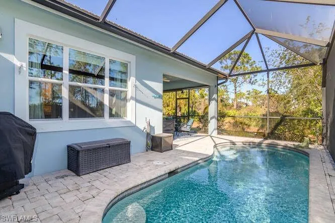 Swimming pool with a screened enclosure, and area for grilling and sunning.