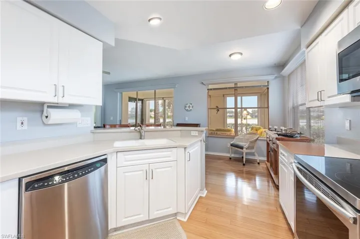 Kitchen featuring sink, kitchen peninsula, white cabinets, and stainless steel appliances