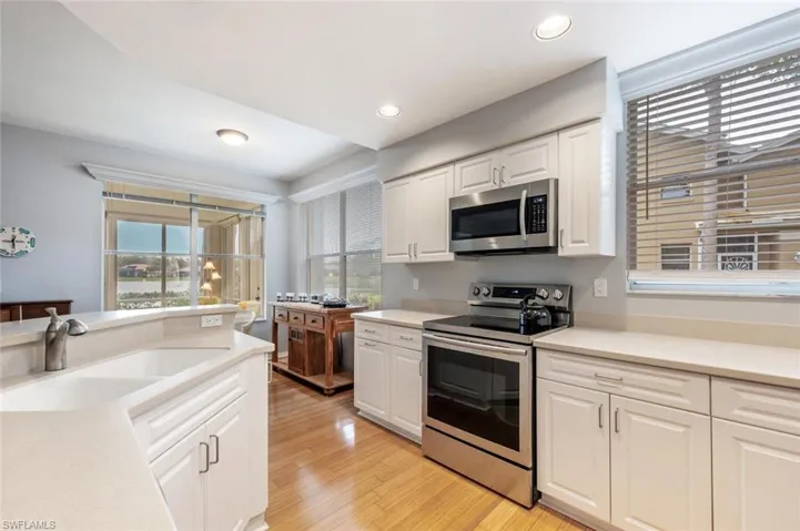 Kitchen featuring light hardwood / wood-style floors, sink, white cabinets, and stainless steel appliances